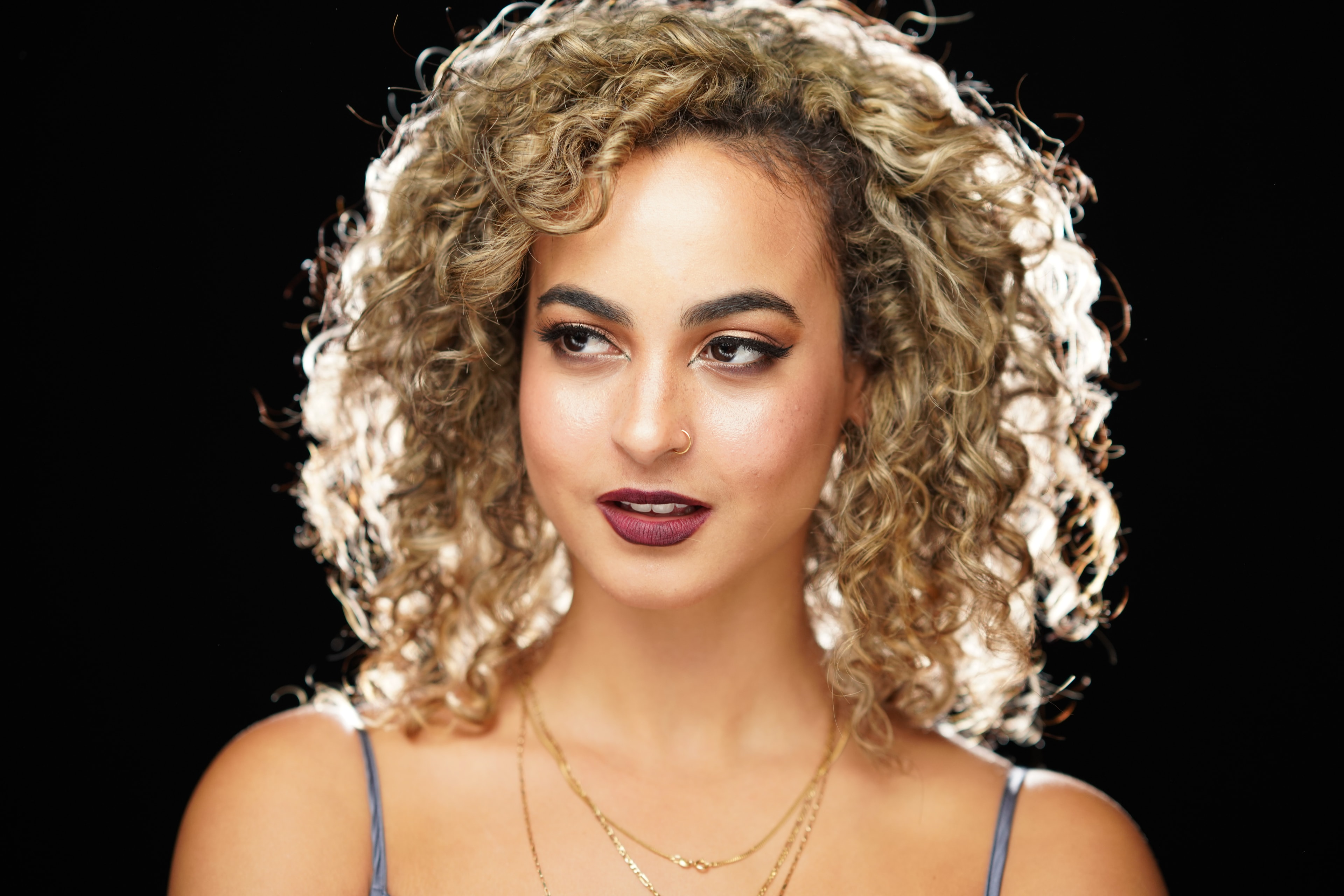 Studio headshot with warm neutral background